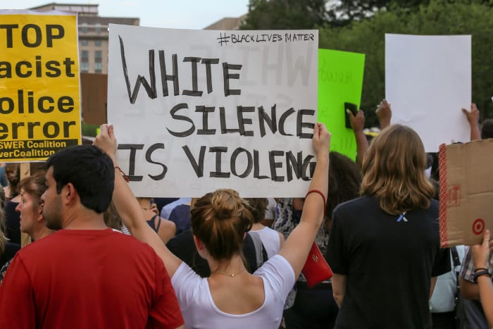 white woman holding up black lives matter sign