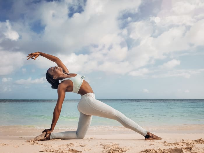 Mia Caine practicing yoga on the beach