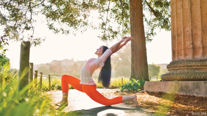 woman doing yoga outside kneeling crescent backbend pose